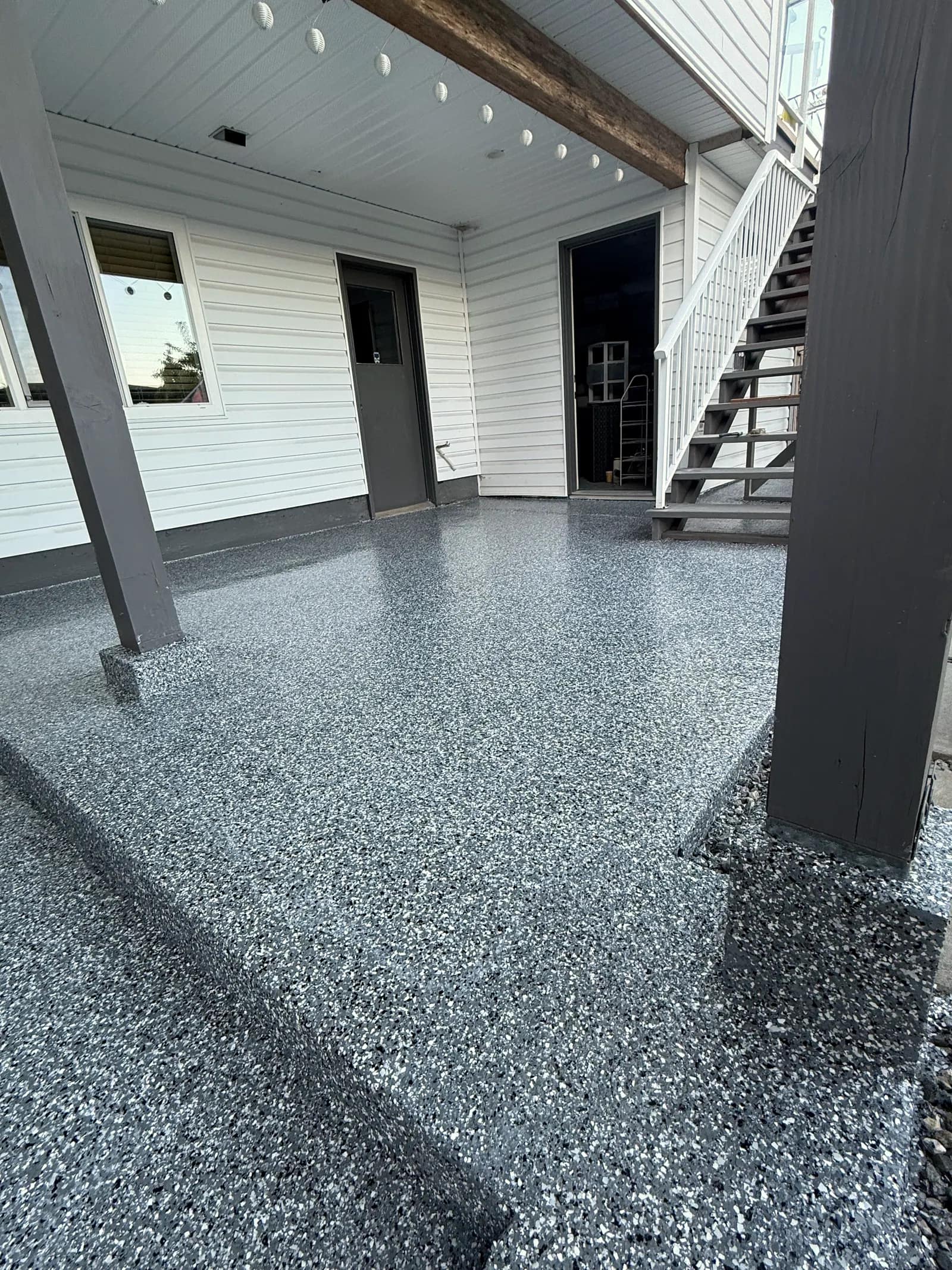 Covered carport with a grey flake coating carried across the slab and up to the base of the posts