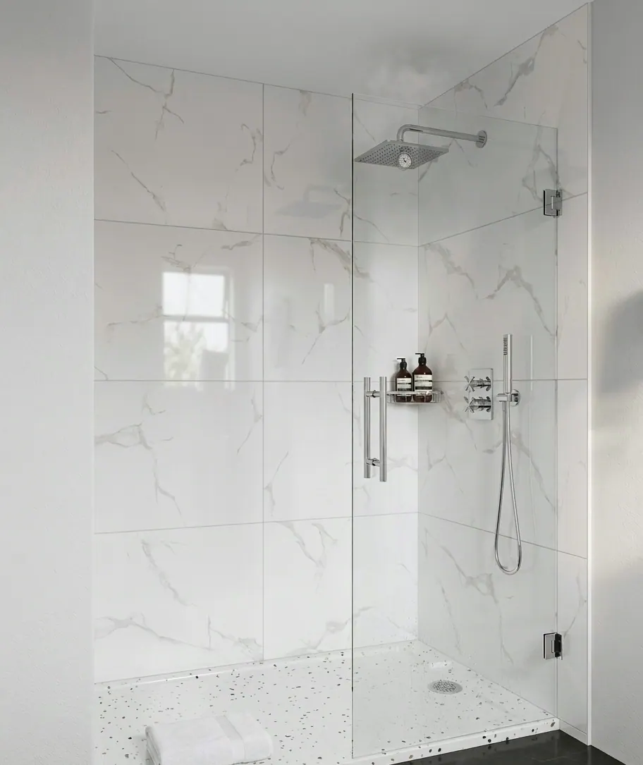 Finished walk-in shower tiled floor to ceiling in large-format marble-look porcelain, with a frameless glass panel, chrome rain head and handheld, and a speckled terrazzo-look shower pan